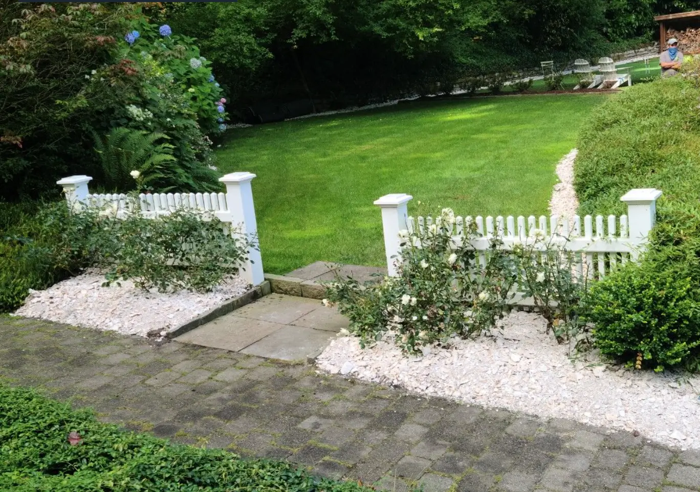 lush green landscape with crushed oyster shell pathway and rustic, low picket fence
